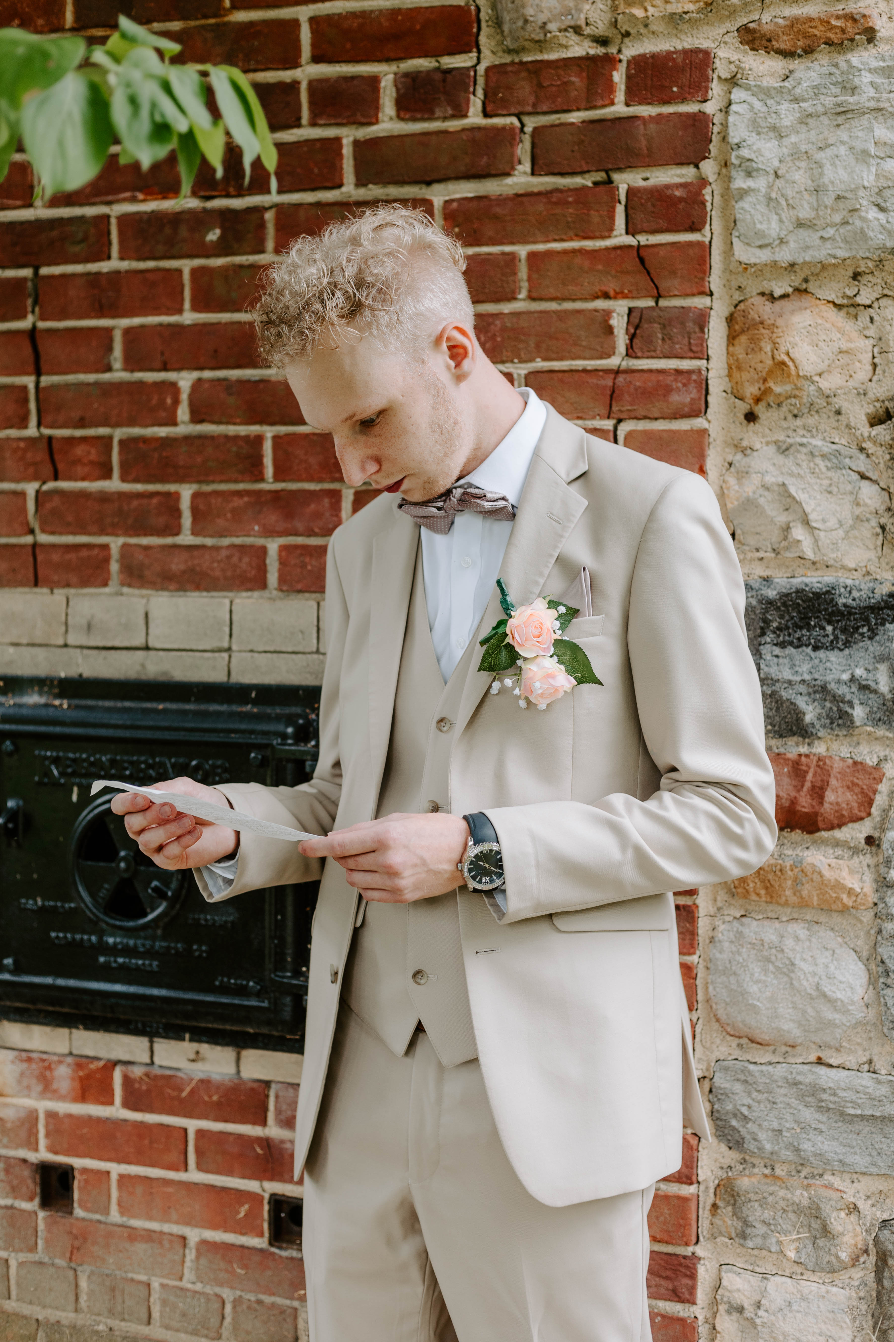 Groom reading a letter from his bride during the first touch at a Delaware spring wedding in historic Odessa. Wedding Photography by Alli McGrath Photography