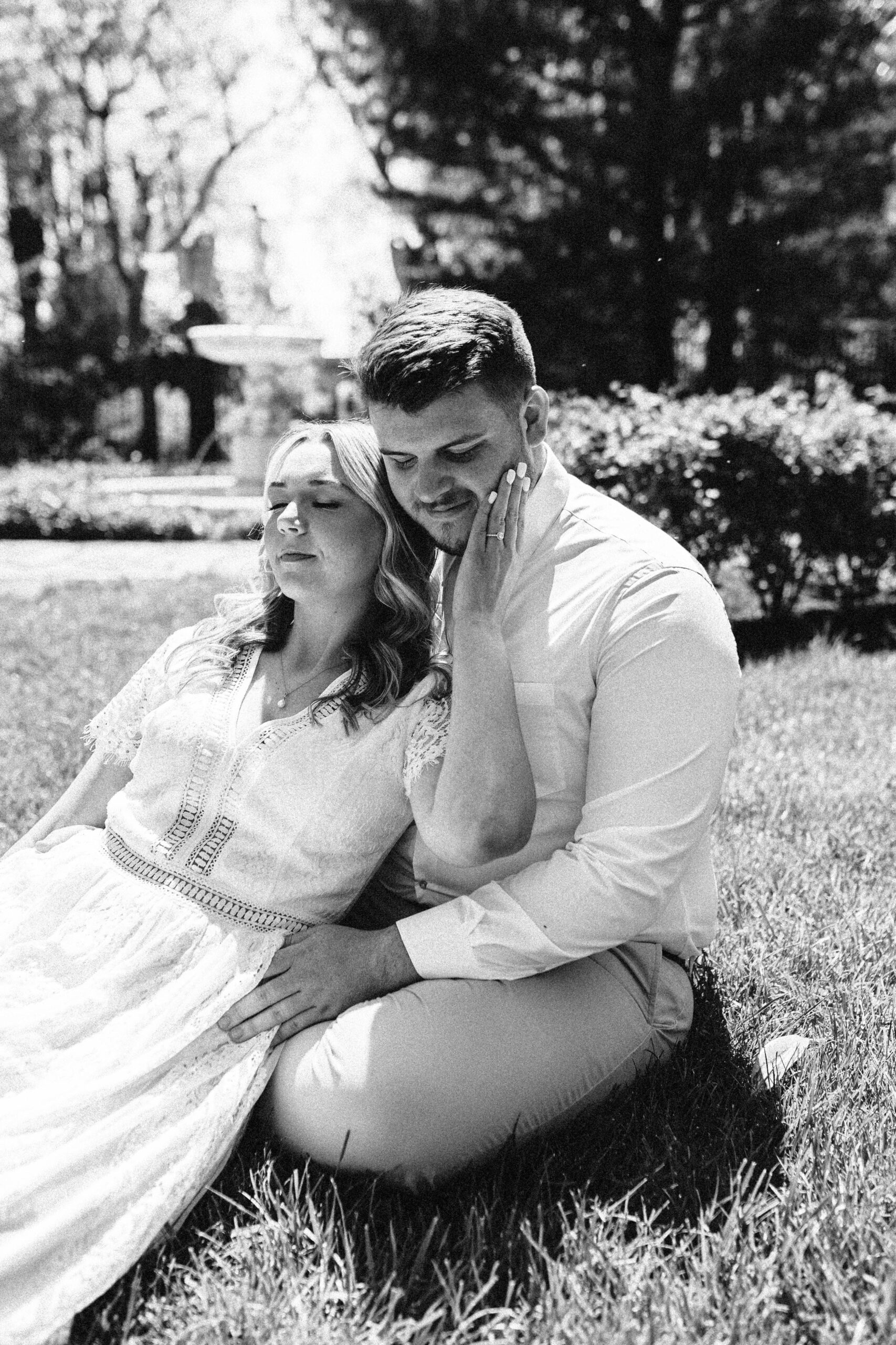 A couple cuddling in a garden in Delaware for engagement photos